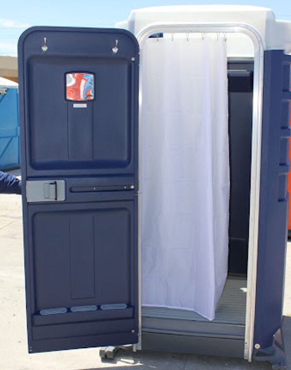 Open portable shower unit with a white shower curtain inside, displayed in an outdoor setting.