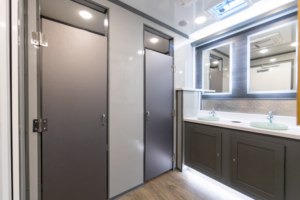 Interior of a mobile bathroom with dual sinks and mirror