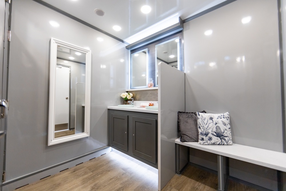 Interior of a modern mobile bathroom with grey cabinetry and seating area