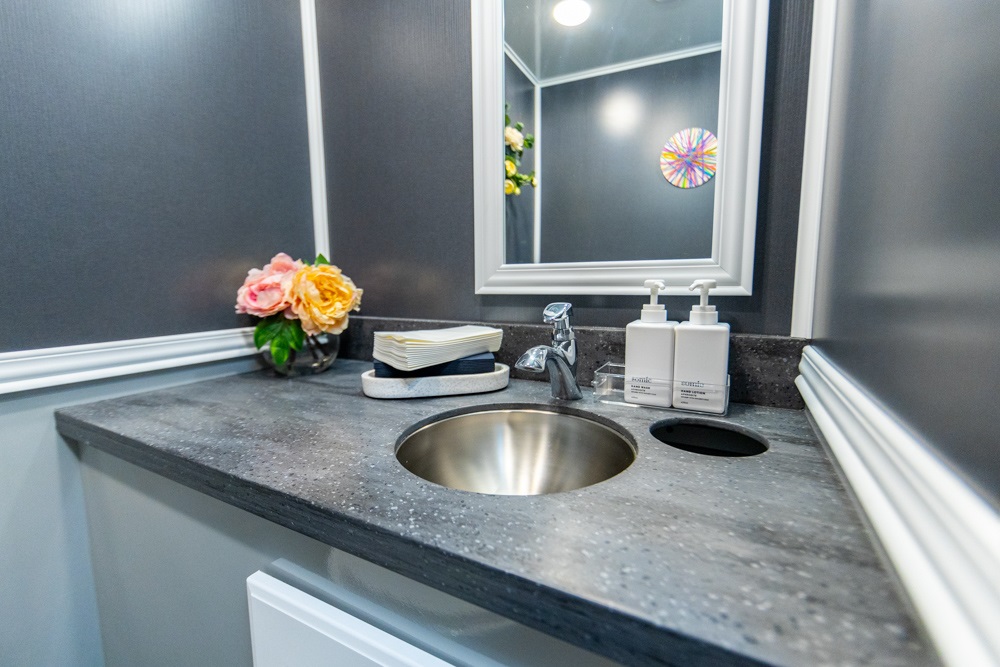 Modern bathroom vanity with sink, mirror, and decorative flowers