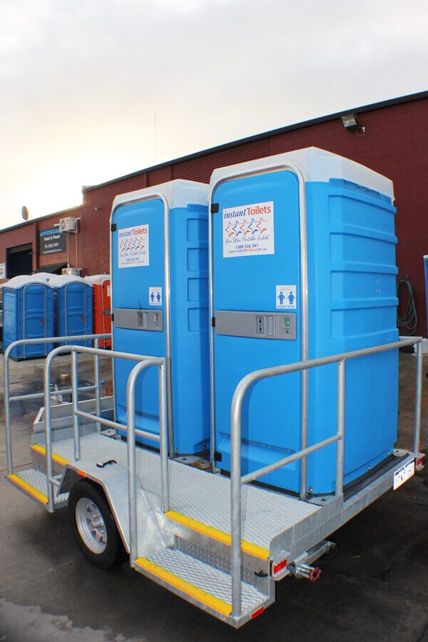 Blue Five Star Duo Mobile Function Toilet on a trailer in an industrial setting.