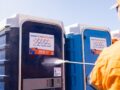 how do i stop my portable toilet from smelling - Worker cleaning portable toilets with a high-pressure washer.