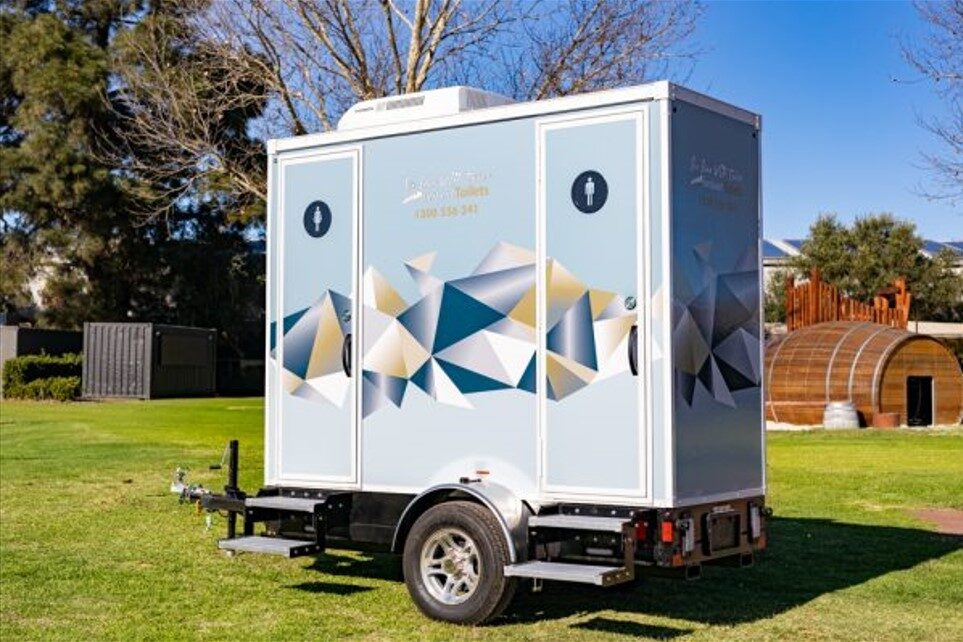 Portable toilet 2-pan series parked on a grassy area